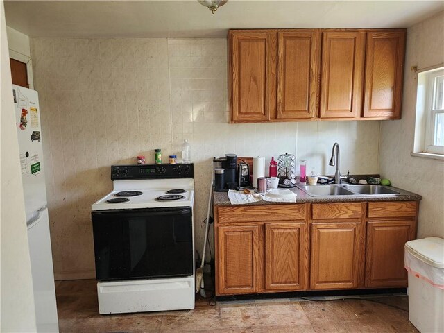 305 Charles Ter, Jeannette, PA 15644 - kitchen with range with electric cooktop, a sink, brown cabinets, and freestanding refrigerator