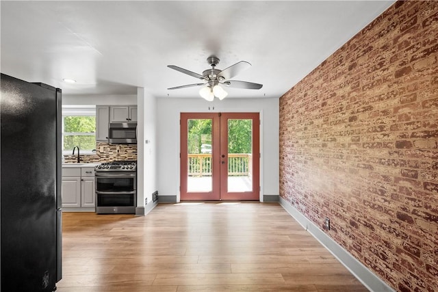 804 Division St, West Mifflin, PA 15122 - interior space featuring french doors, a ceiling fan, baseboards, a sink, and light wood-style floors