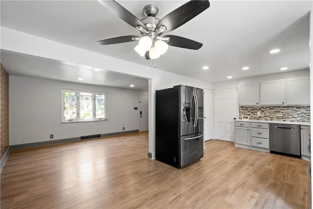 804 Division St, West Mifflin, PA 15122 - kitchen featuring appliances with stainless steel finishes, backsplash, light countertops, light wood-style flooring, and recessed lighting