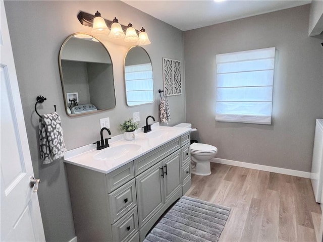 254 Bicker Rd, Winfield Twp, PA 16023 - bathroom featuring wood finished floors, double vanity, toilet, and baseboards
