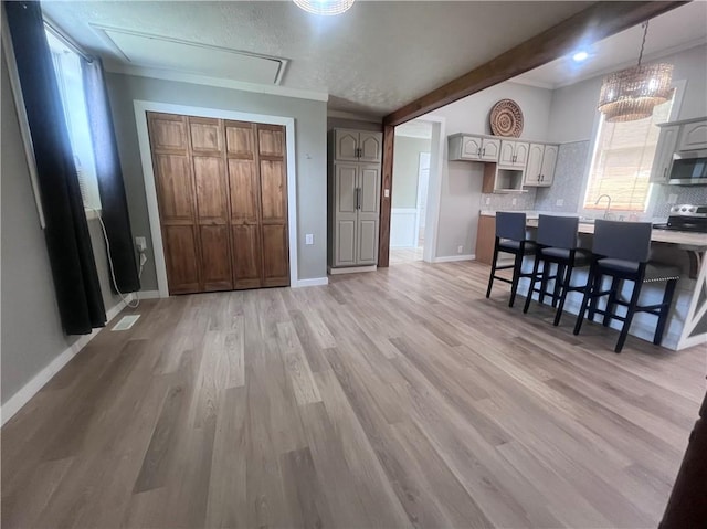 254 Bicker Rd, Winfield Twp, PA 16023 - kitchen featuring stainless steel appliances, decorative backsplash, light wood-style floors, a kitchen bar, and beam ceiling