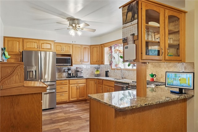 240 Patton Dr, Moon/Crescent Twp, PA 15108 - kitchen with stainless steel appliances, a sink, light stone counters, glass insert cabinets, and a peninsula