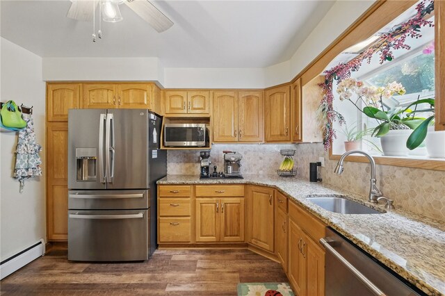240 Patton Dr, Moon/Crescent Twp, PA 15108 - kitchen featuring stainless steel appliances, a sink, light stone counters, a baseboard radiator, and decorative backsplash