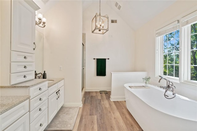 623 Oswego Dr, Adams Twp, PA 15044 - full bath featuring wood finished floors, vanity, a soaking tub, baseboards, and a chandelier