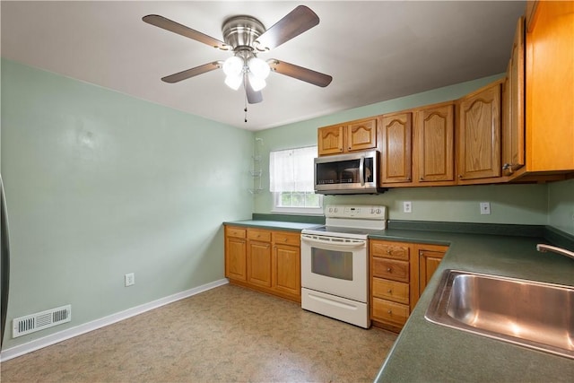 1853 Montour St, Coraopolis, PA 15108 - kitchen with stainless steel microwave, white range with electric cooktop, a sink, dark countertops, and a ceiling fan