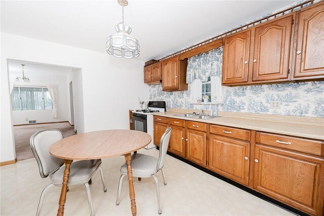 38 Locust St, Center Twp/Homer Cty, PA 15731 - kitchen featuring white gas range oven, brown cabinetry, light countertops, and a chandelier