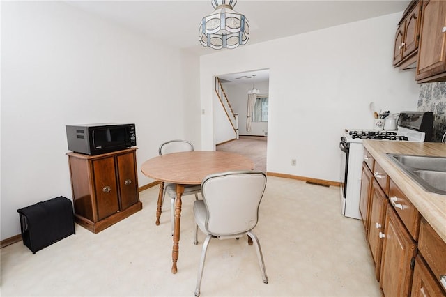 38 Locust St, Center Twp/Homer Cty, PA 15731 - kitchen with white gas range, black microwave, light countertops, baseboards, and a sink