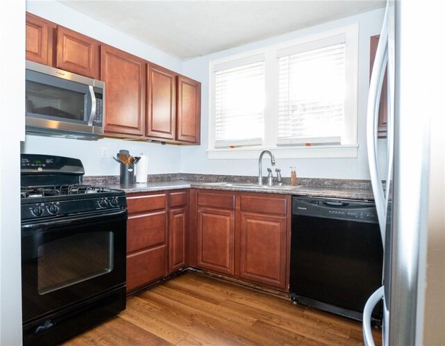 710 Beaver St, Leetsdale, PA 15056 - kitchen featuring black appliances, a sink, dark countertops, wood finished floors, and brown cabinets