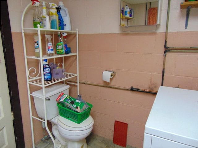 822 Fayette City Rd, Washington Twp, PA 15438 - bathroom with concrete block wall, toilet, and washer / clothes dryer