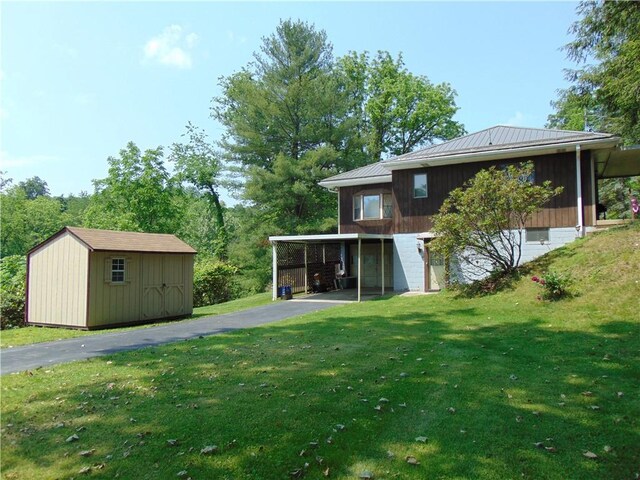 822 Fayette City Rd, Washington Twp, PA 15438 - rear view of property featuring asphalt driveway, an attached garage, metal roof, and a yard