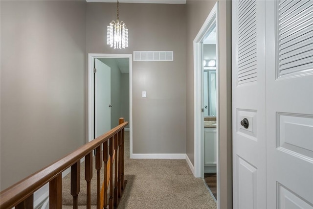 208 Green Ct, Castle Shannon, PA 15234 - hall featuring dark colored carpet, a chandelier, an upstairs landing, and baseboards