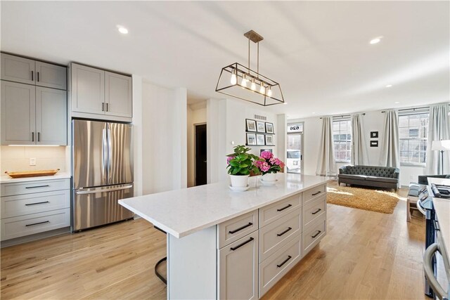 626 Suismon St, East Allegheny, PA 15212 - kitchen with appliances with stainless steel finishes, gray cabinets, open floor plan, light wood finished floors, and pendant lighting