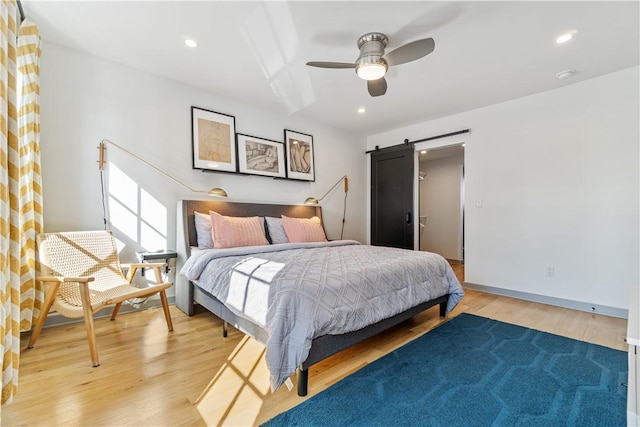 626 Suismon St, East Allegheny, PA 15212 - bedroom with a barn door, light wood-type flooring, ceiling fan, recessed lighting, and baseboards