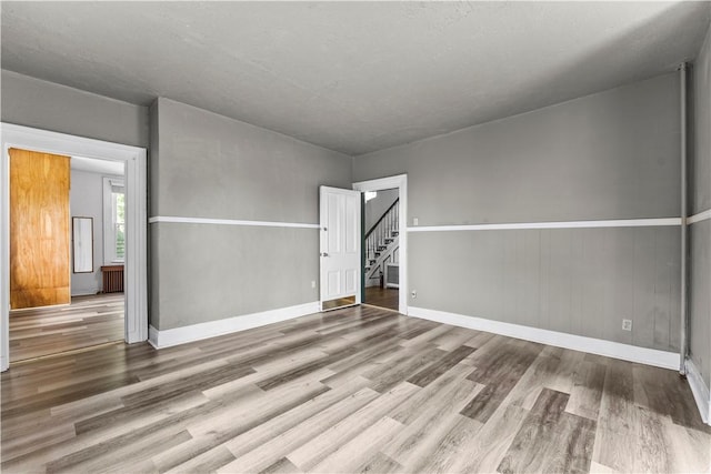 222 Marshall Ave, Observatory Hill, PA 15214 - spare room with wood finished floors, radiator heating unit, stairway, and baseboards