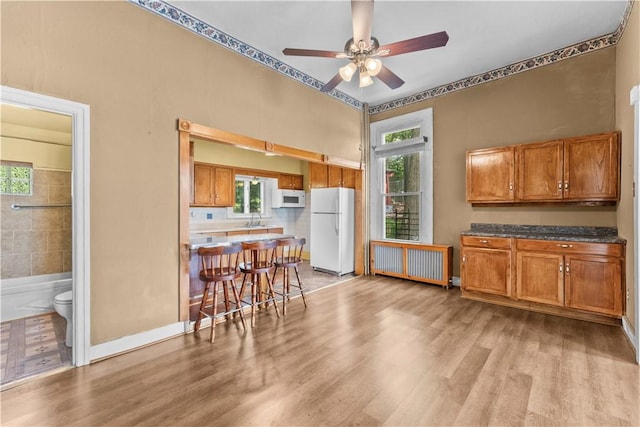222 Marshall Ave, Observatory Hill, PA 15214 - kitchen with white appliances, radiator heating unit, brown cabinetry, and light wood finished floors