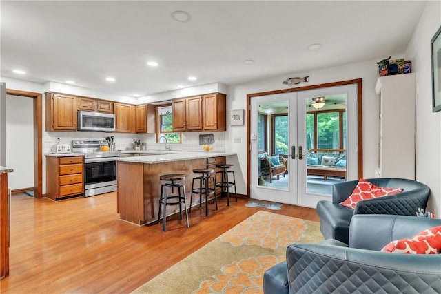 106 Shawnee Dr, Center Twp But, PA 16001 - kitchen with appliances with stainless steel finishes, open floor plan, a peninsula, light wood-style floors, and french doors