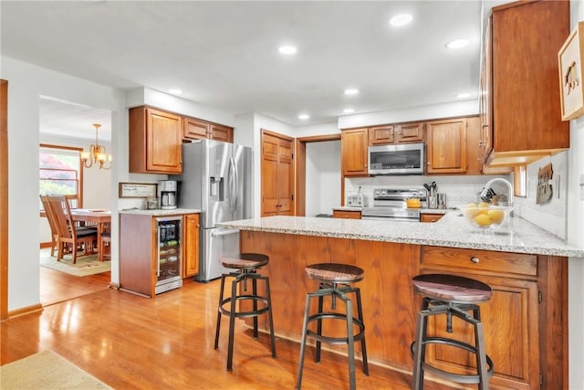 106 Shawnee Dr, Center Twp But, PA 16001 - kitchen featuring stainless steel appliances, wine cooler, a peninsula, light wood-style flooring, and a chandelier
