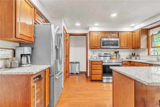 106 Shawnee Dr, Center Twp But, PA 16001 - kitchen featuring appliances with stainless steel finishes, wine cooler, light wood finished floors, a sink, and brown cabinetry