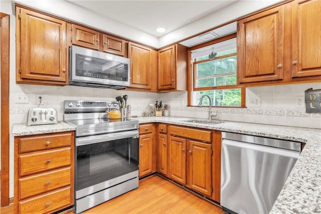 106 Shawnee Dr, Center Twp But, PA 16001 - kitchen featuring stainless steel appliances, a sink, light wood-style floors, brown cabinetry, and recessed lighting