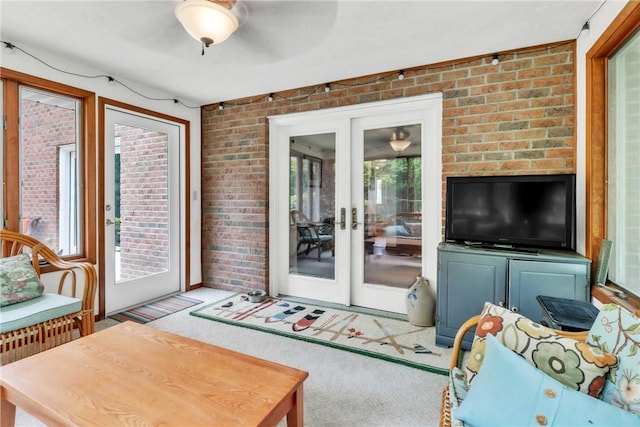 106 Shawnee Dr, Center Twp But, PA 16001 - living room with french doors, brick wall, carpet floors, and a ceiling fan