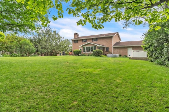 106 Shawnee Dr, Center Twp But, PA 16001 - back of house featuring a jacuzzi, a chimney, brick siding, and a yard