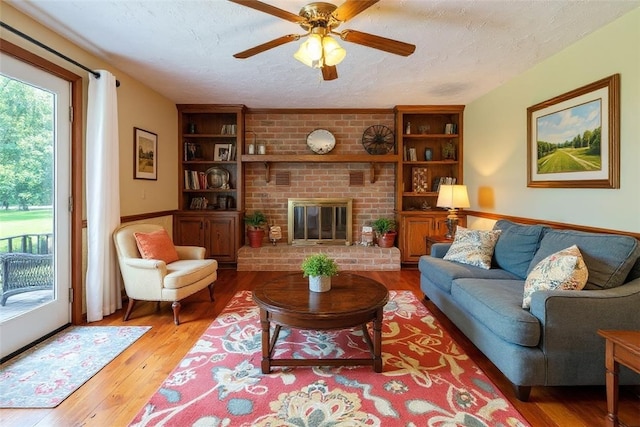 106 Shawnee Dr, Center Twp, PA 16001 - living area with a textured ceiling, healthy amount of natural light, hardwood / wood-style floors, ceiling fan, and a brick fireplace