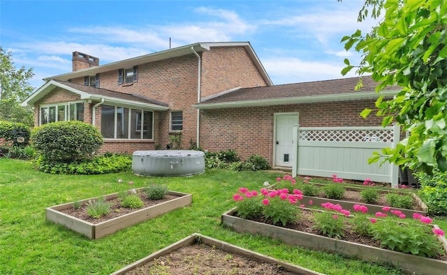 106 Shawnee Dr, Center Twp, PA 16001 - rear view of house with a garden, brick siding, a chimney, and a yard