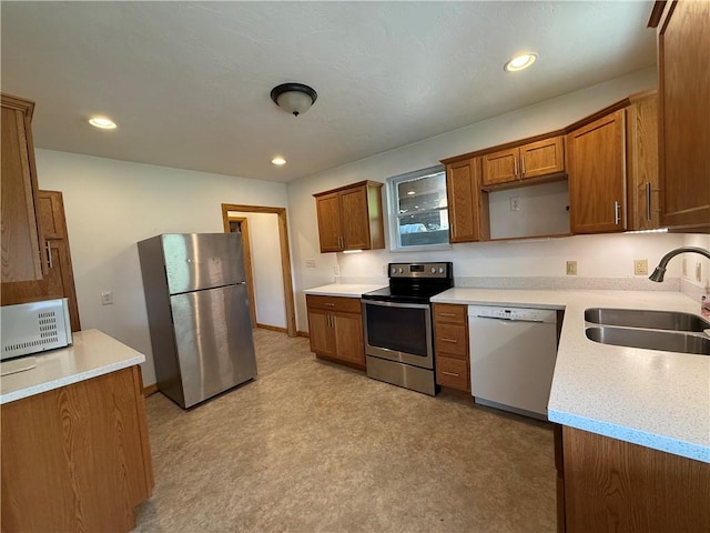 635 Valley St, Oakmont, PA 15139 - kitchen with stainless steel appliances, a sink, brown cabinets, light countertops, and recessed lighting