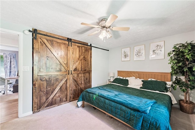 102 Castle Hill Rd, Monroeville, PA 15146 - bedroom with a barn door, a textured ceiling, carpet, and a ceiling fan