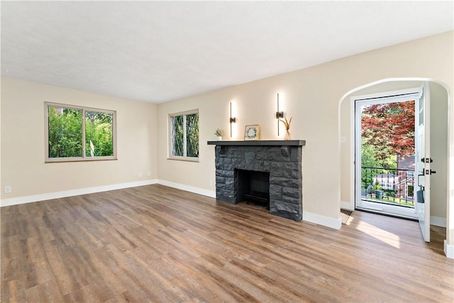 4649 Rolling Hills Rd, Whitehall, PA 15236 - unfurnished living room with wood finished floors, a fireplace, baseboards, and arched walkways