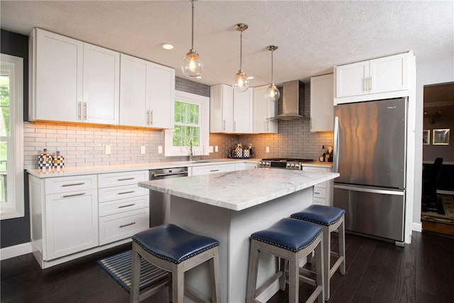 407 Highland Ct, Marshall, PA 15090 - kitchen with stainless steel appliances, wall chimney exhaust hood, a breakfast bar area, dark wood finished floors, and a textured ceiling