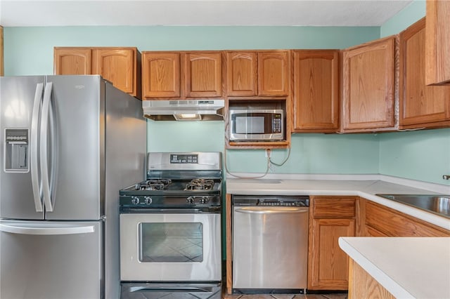 1913 Saint Paul St, South Side, PA 15203 - kitchen with appliances with stainless steel finishes, under cabinet range hood, light countertops, a sink, and tile patterned flooring