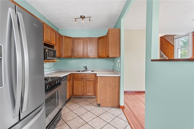 1913 Saint Paul St, South Side, PA 15203 - kitchen with appliances with stainless steel finishes, a sink, light countertops, light tile patterned flooring, and brown cabinets