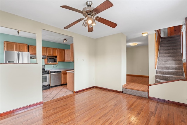 1913 Saint Paul St, South Side, PA 15203 - unfurnished living room featuring light wood-type flooring, stairs, a ceiling fan, and baseboards
