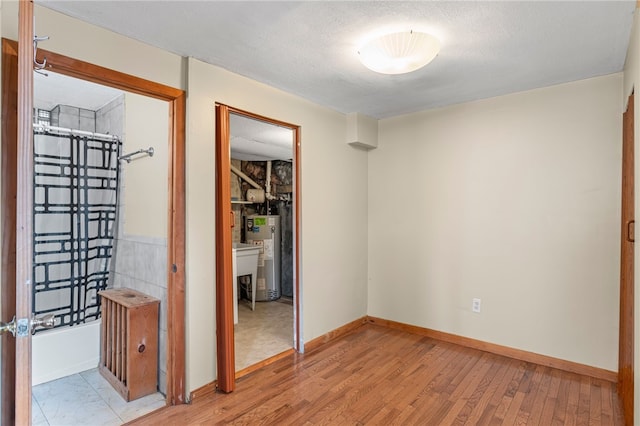 1913 Saint Paul St, South Side, PA 15203 - unfurnished bedroom with gas water heater, light wood finished floors, baseboards, and a closet