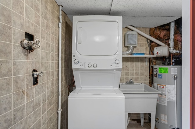 1913 Saint Paul St, South Side, PA 15203 - laundry room with stacked washer and clothes dryer, water heater, and tile walls