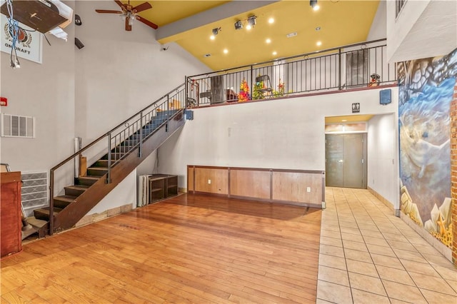 2512 E Carson St, South Side, PA 15203 - unfurnished living room with high vaulted ceiling, wood finished floors, ceiling fan, beam ceiling, and stairway