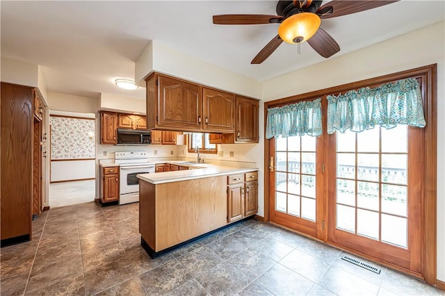 28 Saddlebrook Dr, Hempfield Twp Wml, PA 15601 - kitchen featuring white electric stove, black microwave, a peninsula, light countertops, and a sink