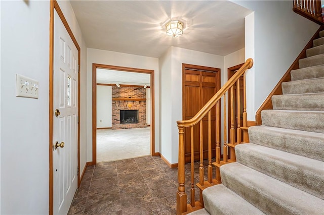 28 Saddlebrook Dr, Hempfield Twp Wml, PA 15601 - foyer entrance featuring stairway, baseboards, a fireplace, dark stone finish flooring, and dark carpet