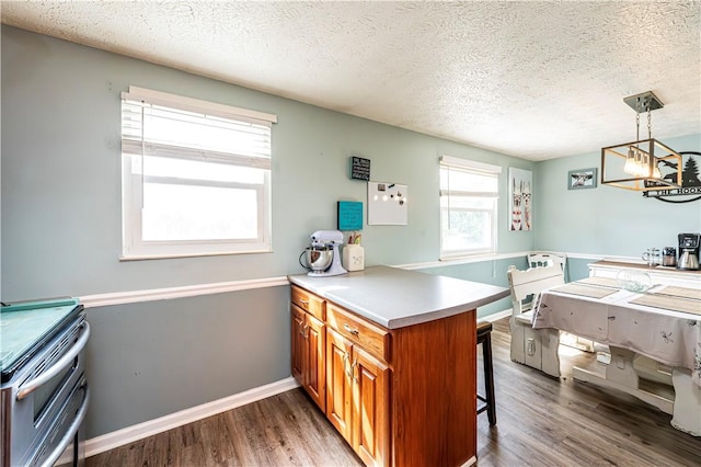1941 Ivanhoe Dr, North Huntingdon, PA 15642 - kitchen featuring a peninsula, a textured ceiling, brown cabinets, wood finished floors, and a kitchen bar