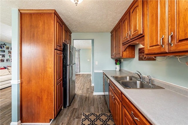 1941 Ivanhoe Dr, North Huntingdon, PA 15642 - kitchen featuring a sink, appliances with stainless steel finishes, dark wood-style flooring, a textured ceiling, and light countertops