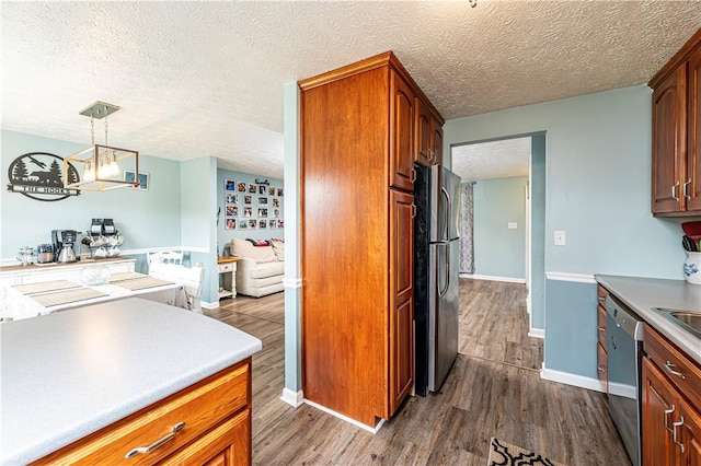 1941 Ivanhoe Dr, North Huntingdon, PA 15642 - kitchen with appliances with stainless steel finishes, dark wood-type flooring, a textured ceiling, baseboards, and decorative light fixtures