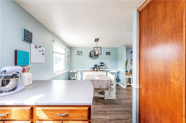 1941 Ivanhoe Dr, North Huntingdon, PA 15642 - kitchen with a chandelier, dark wood finished floors, a textured ceiling, light countertops, and brown cabinetry