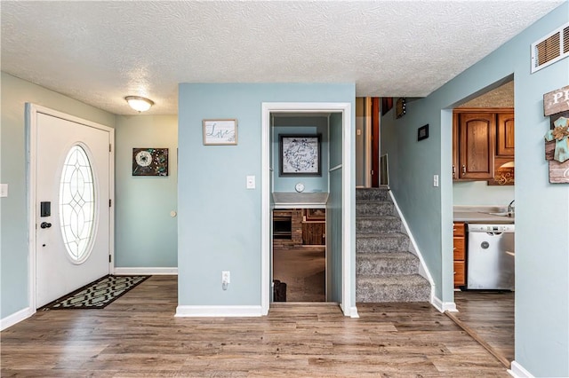 1941 Ivanhoe Dr, North Huntingdon, PA 15642 - entrance foyer with wood finished floors, a textured ceiling, stairway, and baseboards