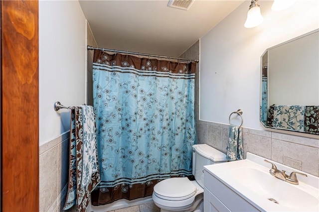 1941 Ivanhoe Dr, North Huntingdon, PA 15642 - full bathroom featuring tile walls, toilet, vanity, wainscoting, and a shower with shower curtain