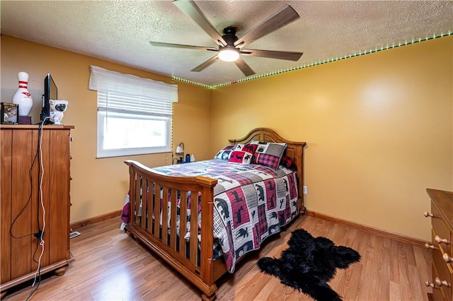 1941 Ivanhoe Dr, North Huntingdon, PA 15642 - bedroom featuring a textured ceiling, wood finished floors, baseboards, and a ceiling fan
