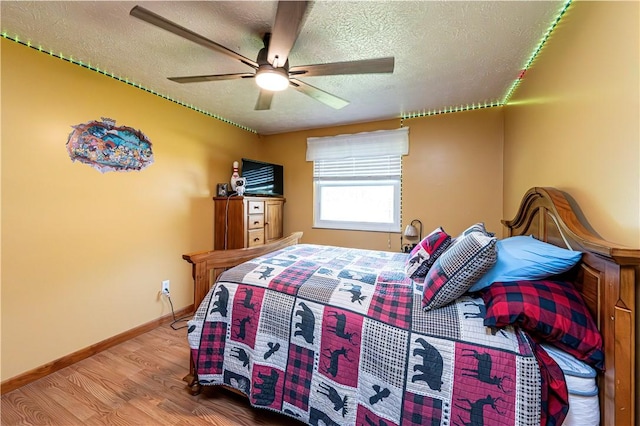 1941 Ivanhoe Dr, North Huntingdon, PA 15642 - bedroom with wood finished floors, a textured ceiling, ceiling fan, and baseboards