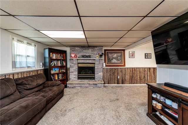 1941 Ivanhoe Dr, North Huntingdon, PA 15642 - carpeted living area featuring a paneled ceiling, wooden walls, and a brick fireplace