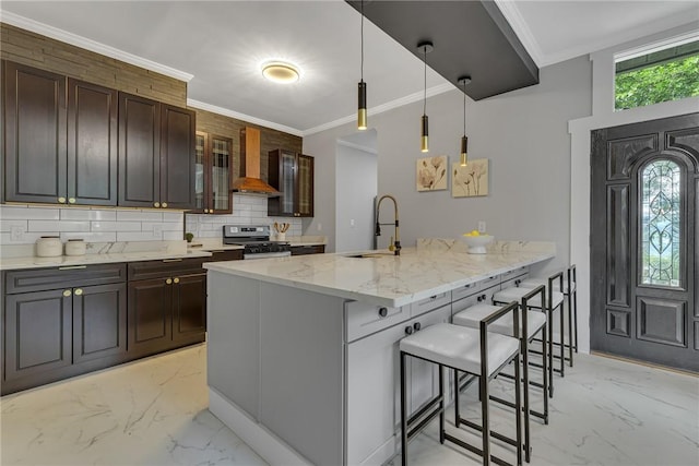 615 Cliff Ave, Bellevue, PA 15202 - kitchen featuring light marble finish flooring, stainless steel range with gas stovetop, a breakfast bar area, premium range hood, and decorative backsplash
