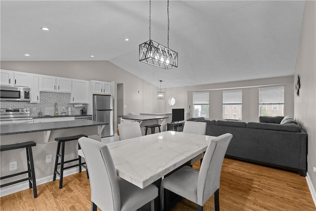 509 Cresthaven Dr, Plum Boro, PA 15239 - dining space with lofted ceiling, light wood-style floors, and a chandelier